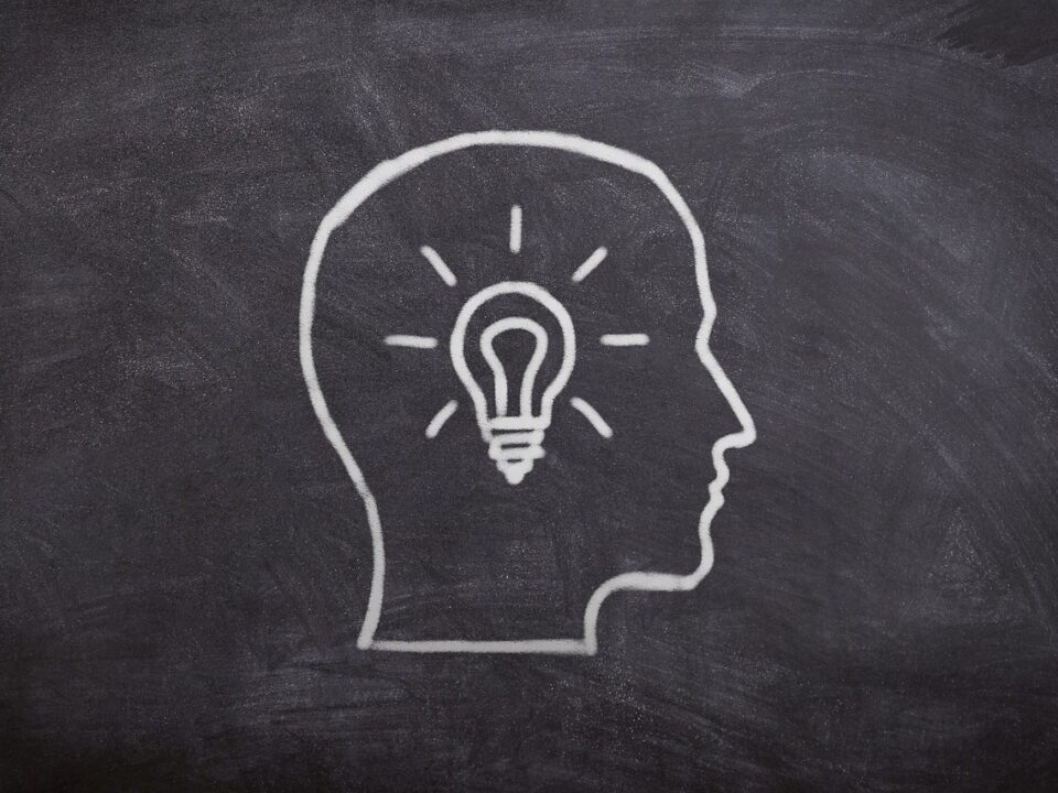 Chalk board drawing of a head and idea symbolized by a light bulb